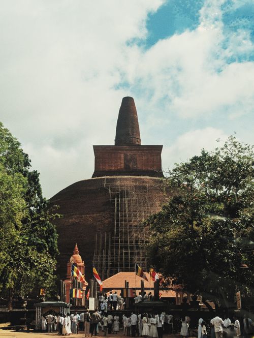 Free Historic Jetavanaramaya Stupa in Anuradhapura, Sri Lanka with visitors and Buddhist flags. Stock Photo