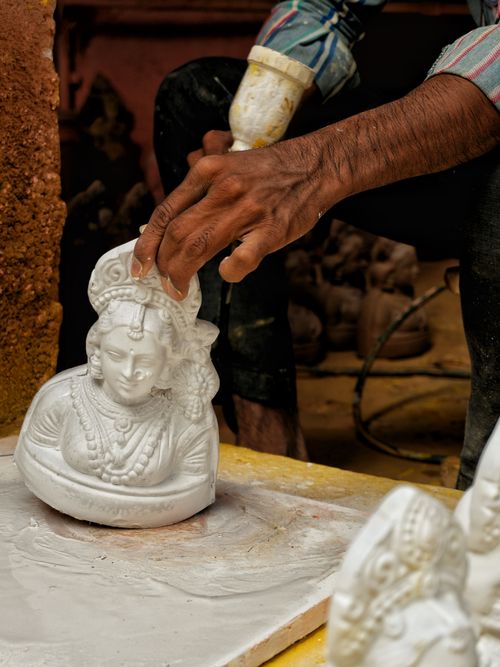 Free Hand of artisan meticulously crafting a marble bust in a Bengaluru workshop, depicting cultural heritage. Stock Photo