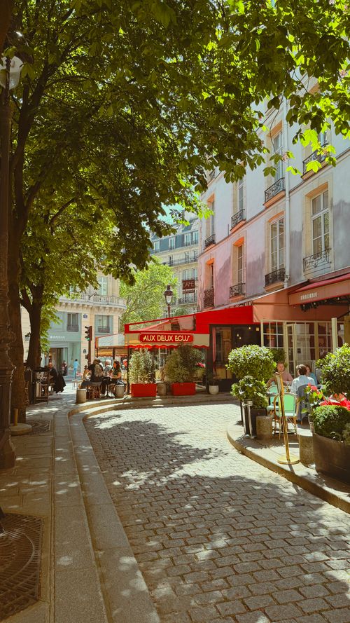 Free A cozy Paris street cafe in summer with people enjoying the ambiance and charm. Stock Photo