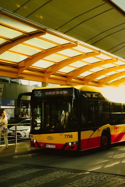 Free Yellow and red public bus at a modern bus stop in Poland during daylight. Stock Photo