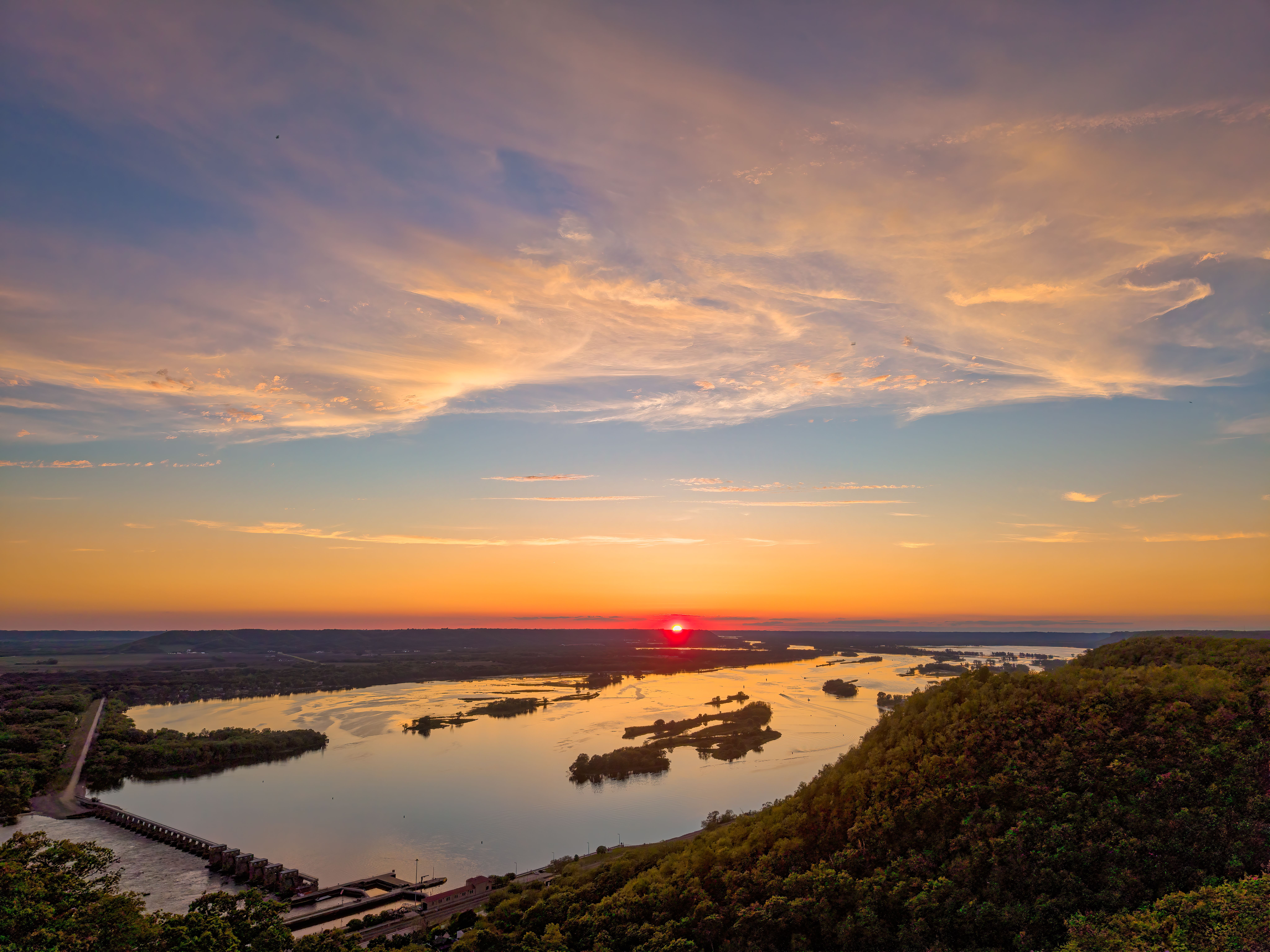 Breathtaking sunset view overlooking the Mississippi River with lush greenery in Alma, Wisconsin.