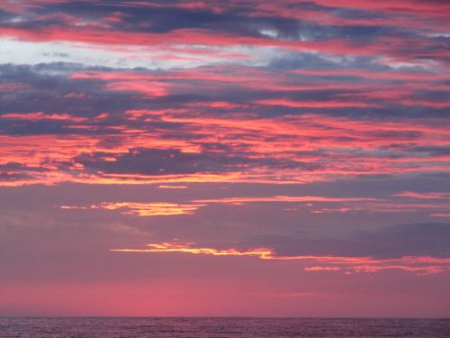 Free Stunning vibrant sunset with pink and purple hues over the ocean. Stock Photo
