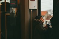 穿着外套的小孩若有所思地凝视着火车窗外，捕捉着布鲁塞尔旅行的瞬间