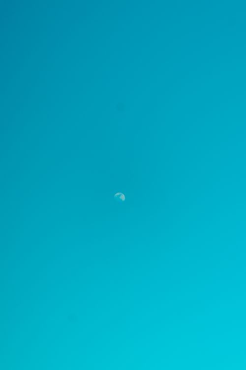 Free A minimalist view of the moon against a clear turquoise sky during the day, showcasing simplicity. Stock Photo