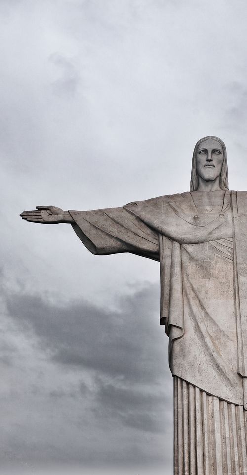 Free Iconic Christ the Redeemer statue overlooking Rio de Janeiro against a cloudy sky. Stock Photo