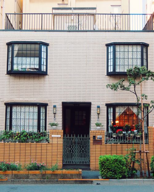 Free A cozy urban residence with lush greenery and decorative window grills. Stock Photo