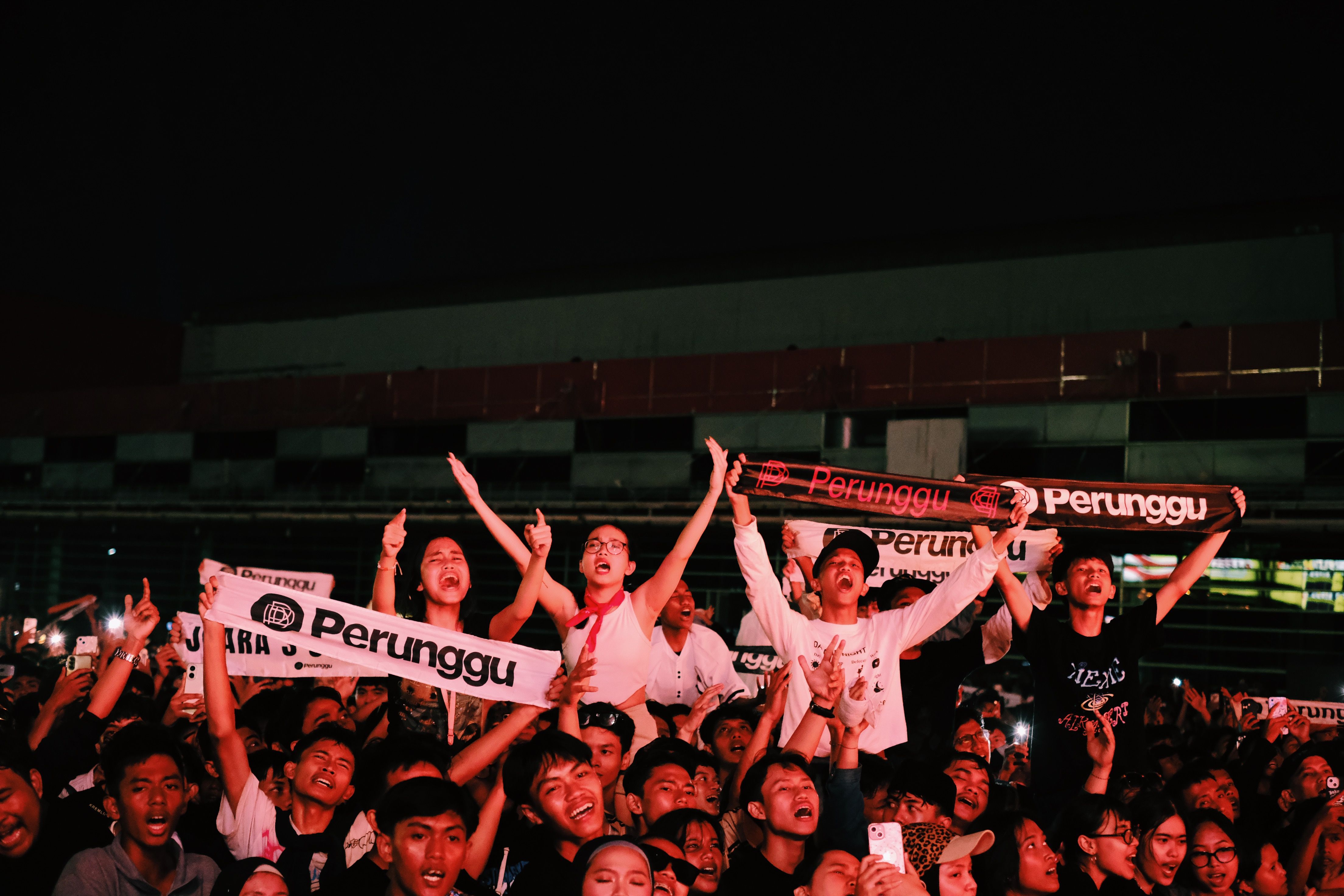 Suporter sepak bola memenuhi stadion besar Amerika Utara dengan bendera Kanada, Meksiko, dan Amerika Serikat