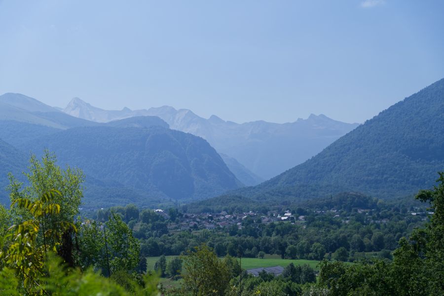 Sunlit Pyrenees valley village framed by distant rocky summits