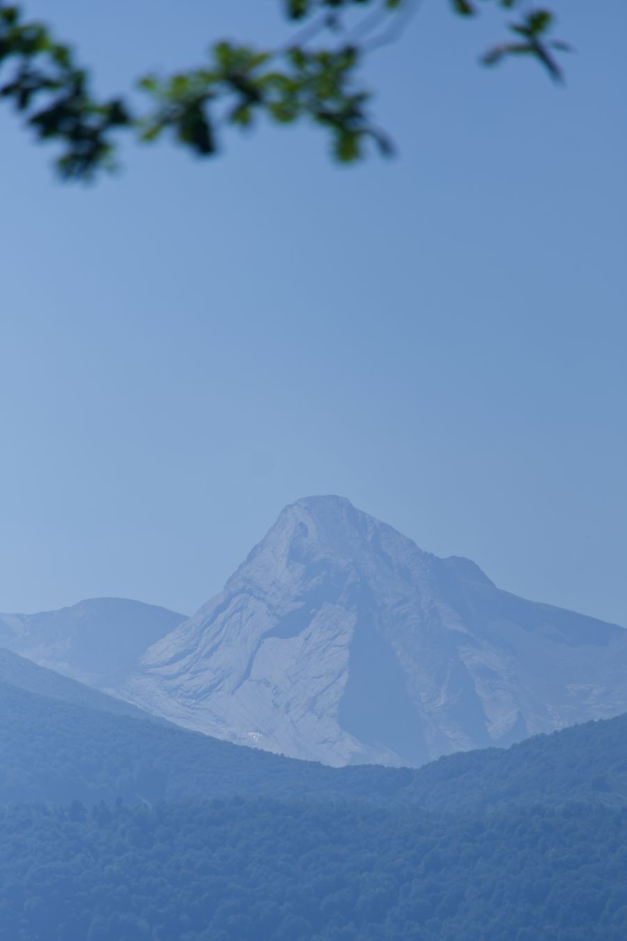 Pic du Midi d'Ossau's distinctive peak rising above hazy foothills