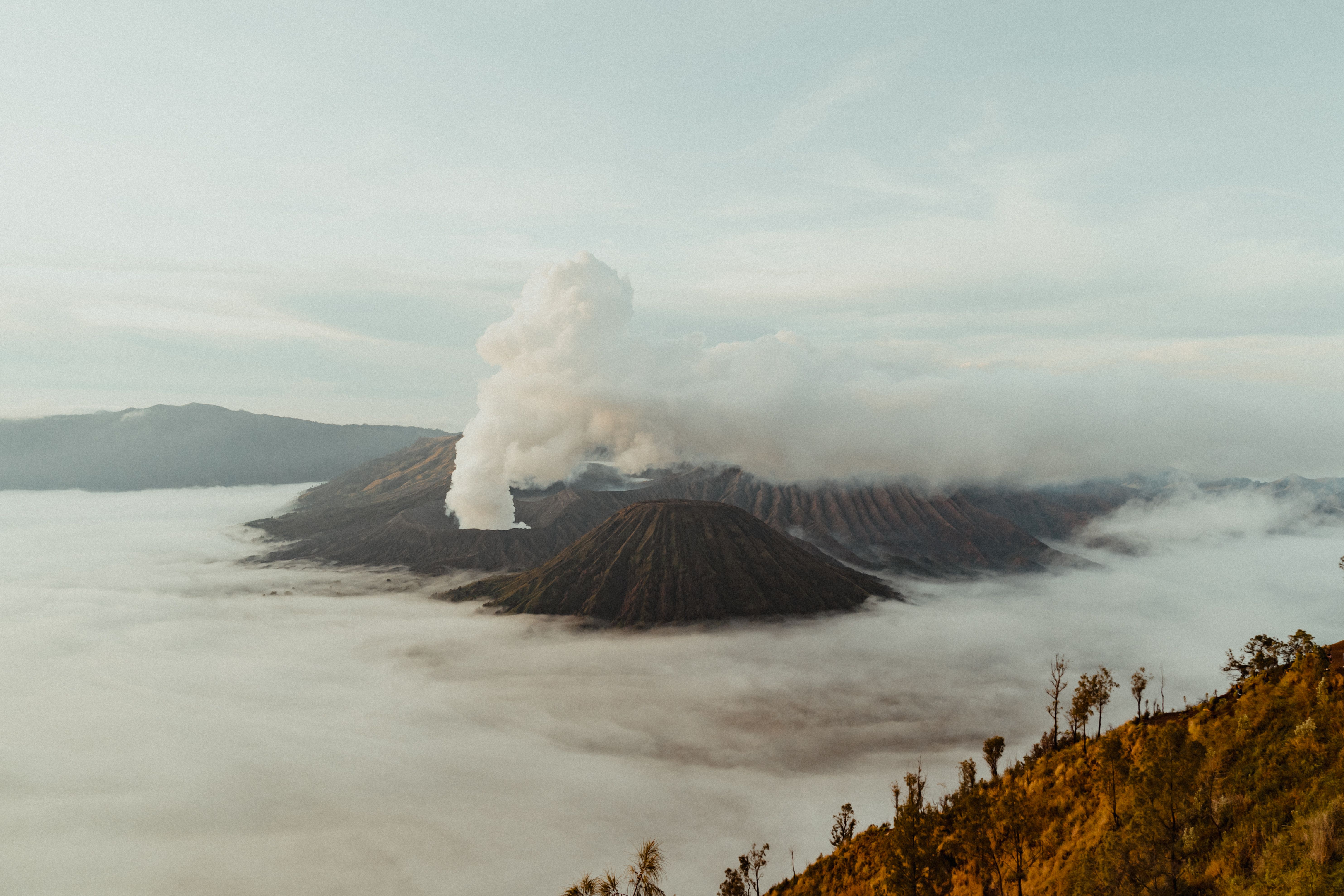 Stunning sunrise landscape of Mount Bromo, East Java, surrounded by mist and clouds, capturing natural beauty.