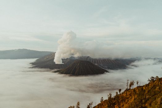 Stunning sunrise landscape of Mount Bromo, East Java, surrounded by mist and clouds, capturing natural beauty.