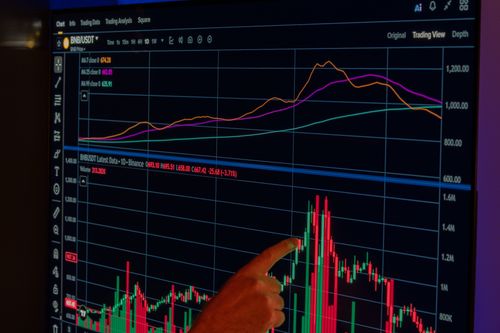 Free A hand points to a dynamic cryptocurrency market chart displayed on a screen, showcasing financial trends. Stock Photo