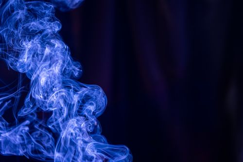 Free Captivating blue smoke swirls gracefully against a deep, dark background, creating an abstract and mysterious visual. Stock Photo