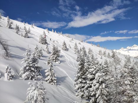 在蔚蓝的天空下，滑雪者可以欣赏到白雪皑皑的高山斜坡，景色令人惊叹