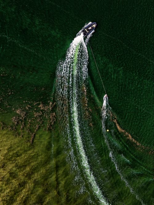 Free A thrilling aerial shot of a speedboat towing a water skier in Exmouth, UK. Stock Photo