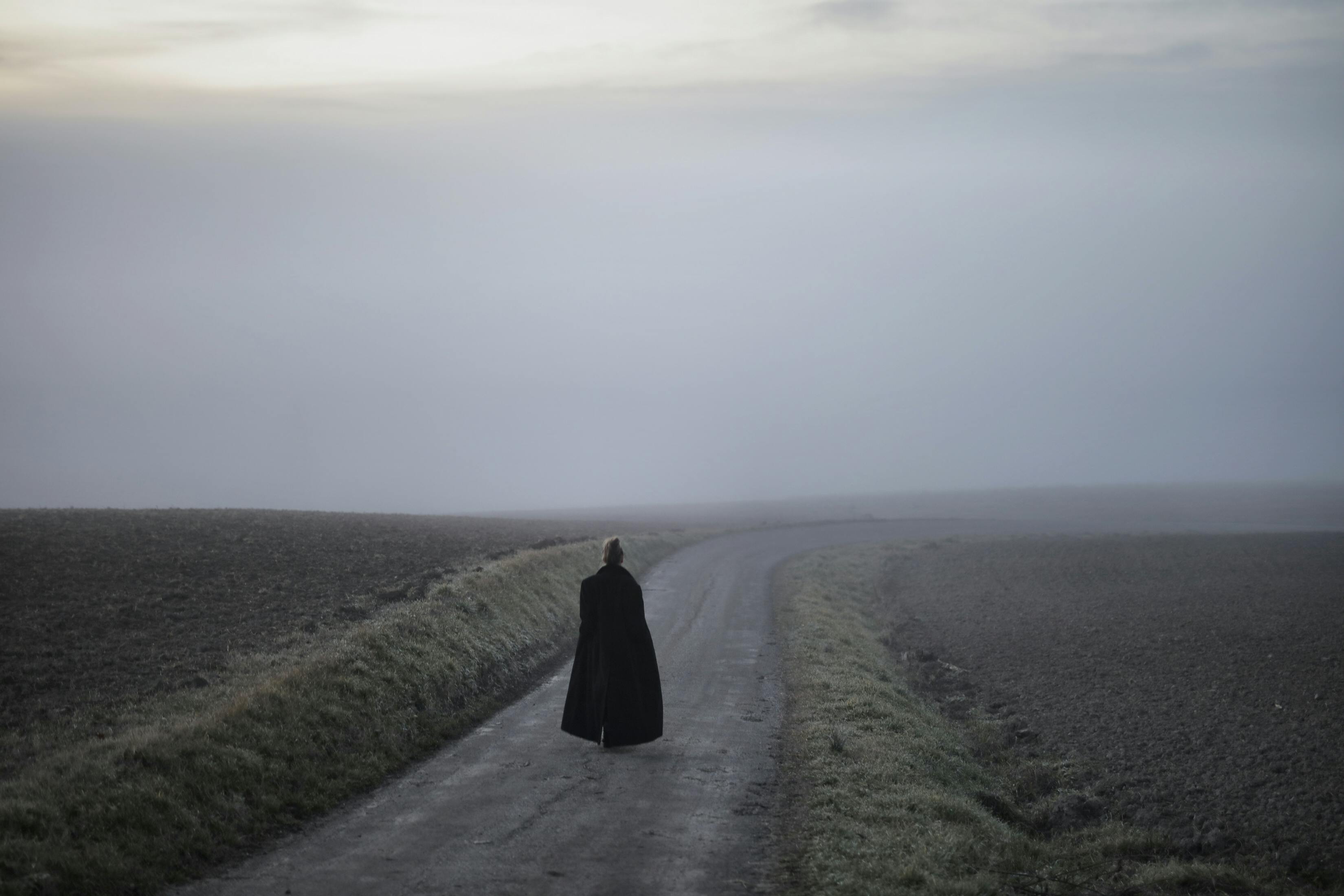 Person in Black Coat Walking on Pathway · Free Stock Photo