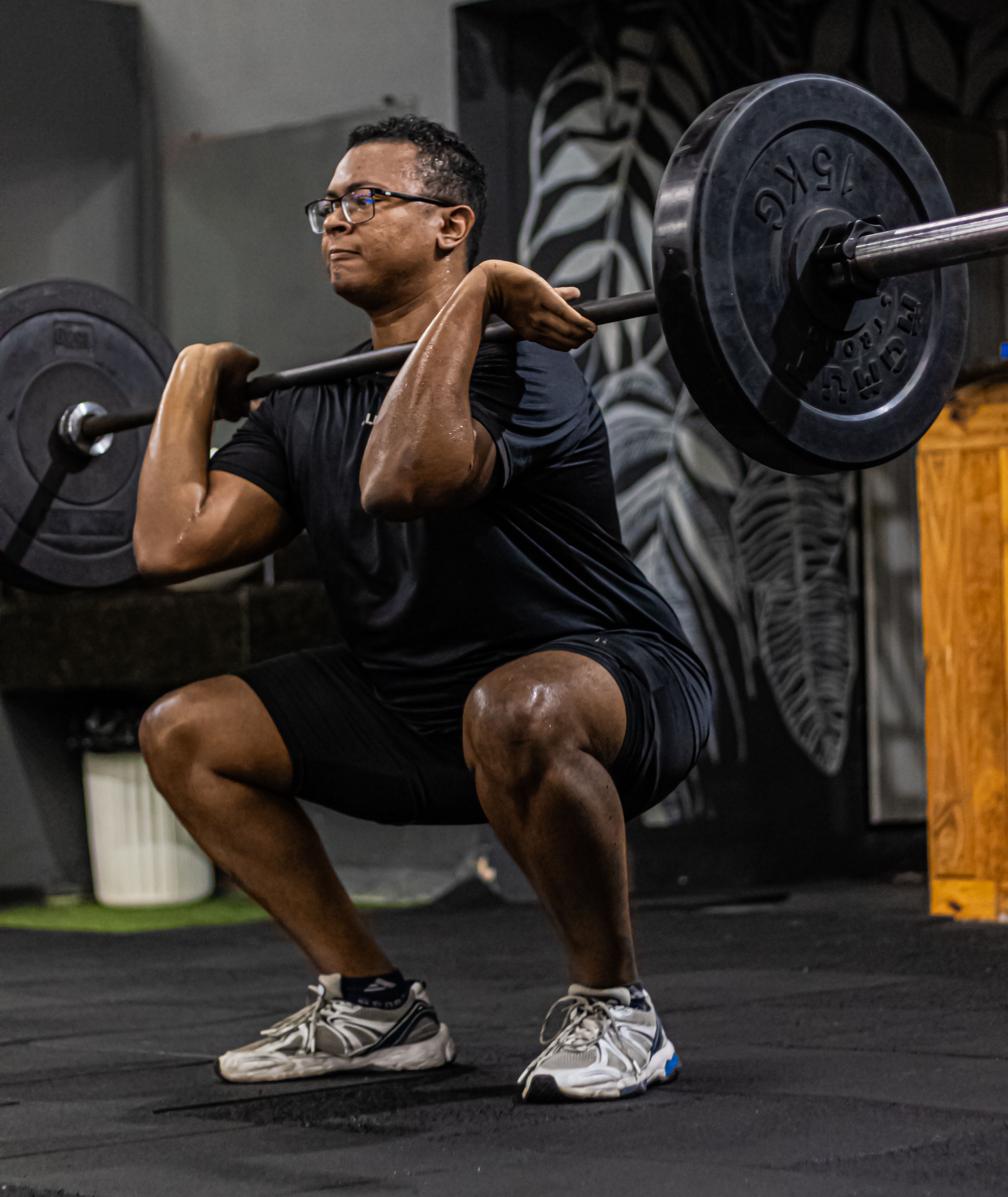 Adult man lifting weights in a gym, demonstrating strength and fitness technique