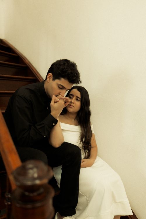 Free A tender moment between a couple seated on a staircase, conveying romance and intimacy. Stock Photo