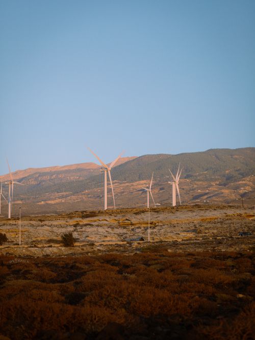 Free Wind turbines in a desert-like landscape of Santa Cruz de Tenerife at sunset. Stock Photo