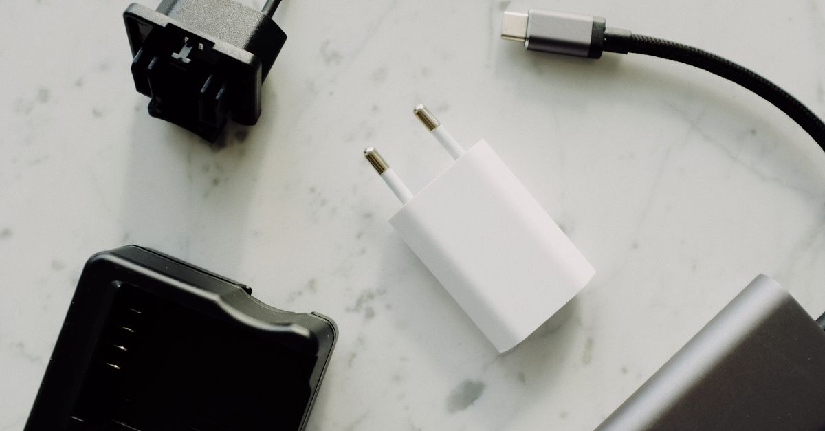 Close-up de USB-C e adaptadores em uma superfície de mármore, destacando essenciais da eletrônica moderna.