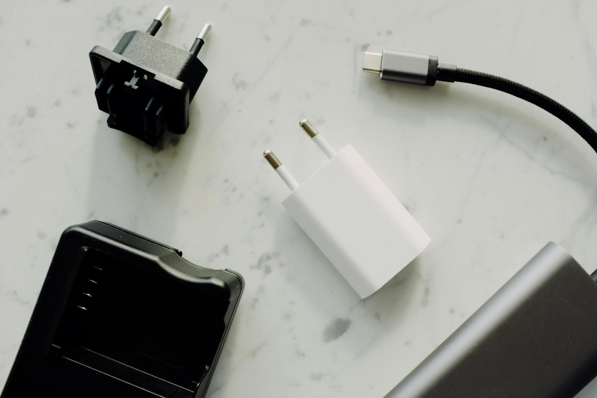 Close-up of USB-C and adaptors on a marble surface, highlighting modern electronics essentials.