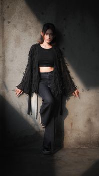 Fashionable young woman posing against a wall in Bandung, Indonesia.