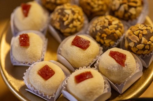 Free Close-up of assorted gourmet truffles featuring almond toppings and custard-filled delights on a plate. Stock Photo