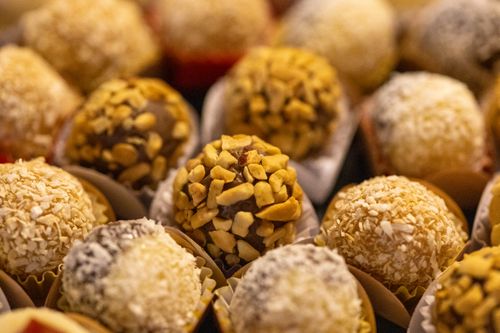 Free Close-up of assorted round truffles with nuts and coconut flakes in focus. Stock Photo