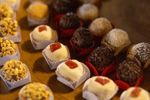 Free Close-up of assorted Brazilian brigadeiros displayed on a wooden table, showcasing a variety of flavors and textures. Stock Photo