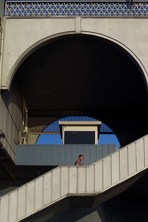 Free Man walking on an outdoor staircase in a modern architectural setting. Stock Photo