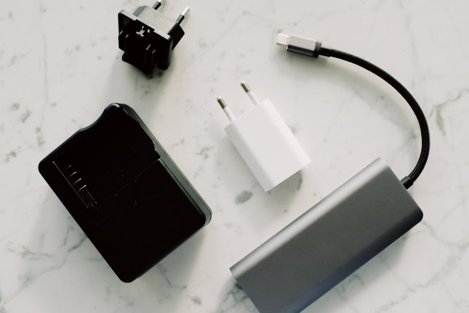 A collection of electronic adapters and cables on a marble surface, showcasing tech essentials.