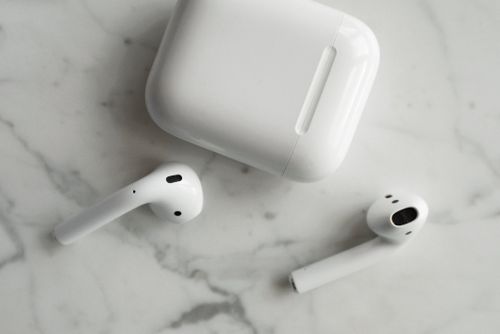 Wireless earbuds beside their charging case. Photo by ready made on Pexels