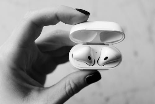 Monochrome Photo of Person Holding Apple Airpods
