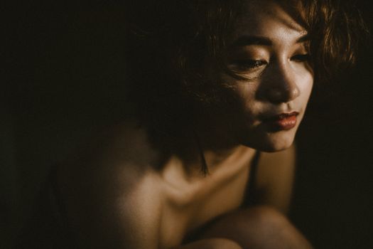 柔和灯光下，一位女子喜怒无常的肖像传达了深刻的情感