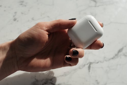 Free Close-Up Photo of Person Holding Airpods Casing Stock Photo