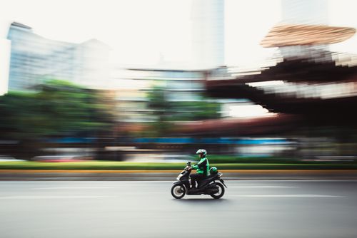 Free Dynamic panning shot of a motorcyclist speeding through city streets, showcasing urban motion. Stock Photo