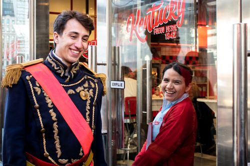 Free Two employees in uniform smiling outside a Kentucky restaurant entrance. Stock Photo