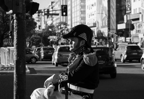 Free A man in historic attire in a bustling city intersection, black and white. Stock Photo