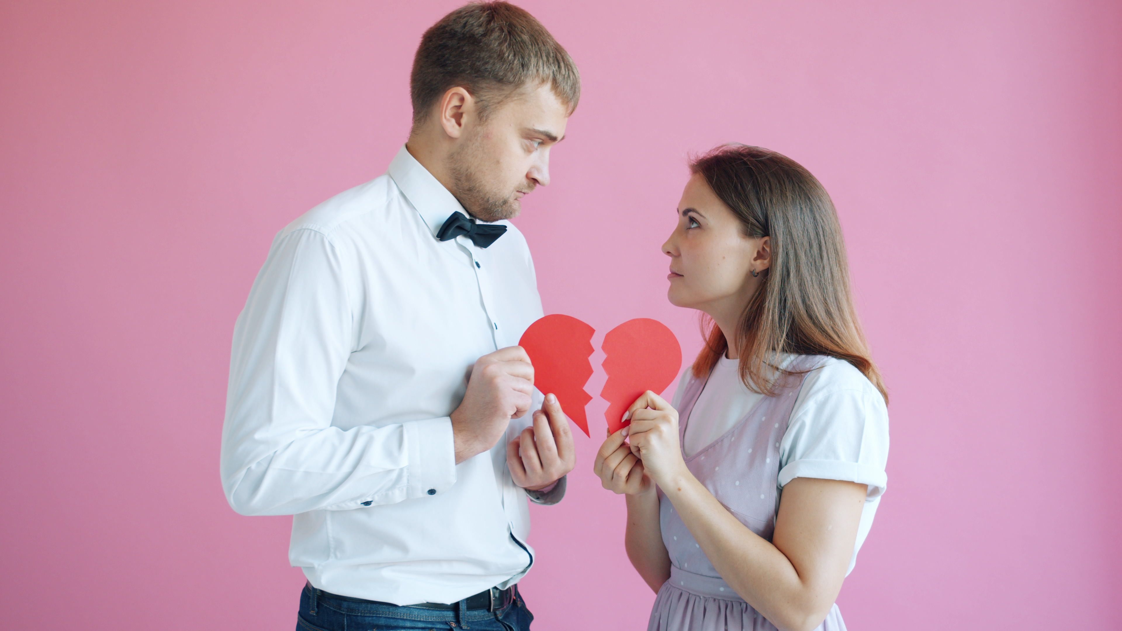 A couple holding a broken heart symbolizing a relationship problem or breakup.