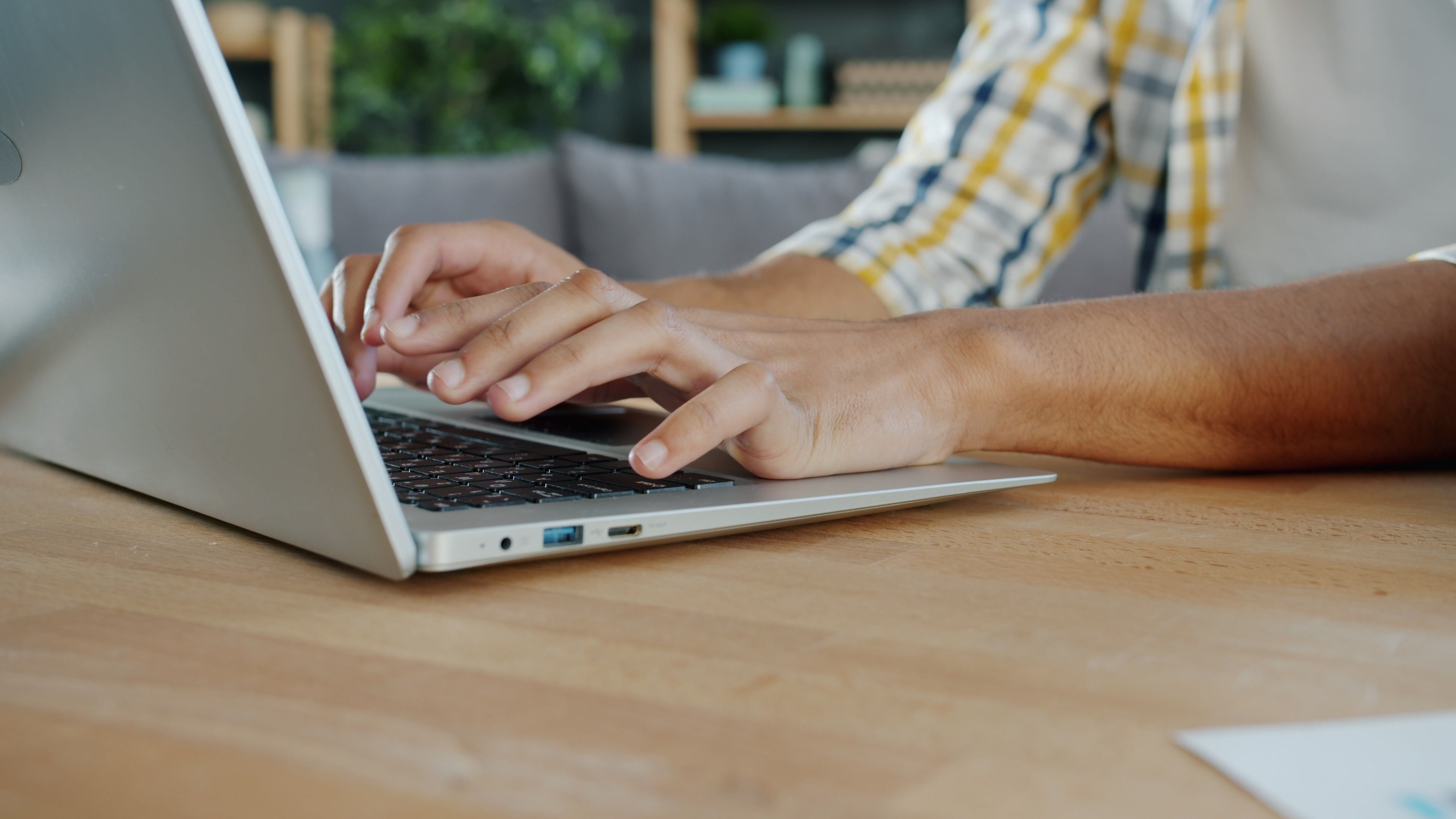 Close-up of hands typing on a laptop indoors, ideal for business and tech themes.