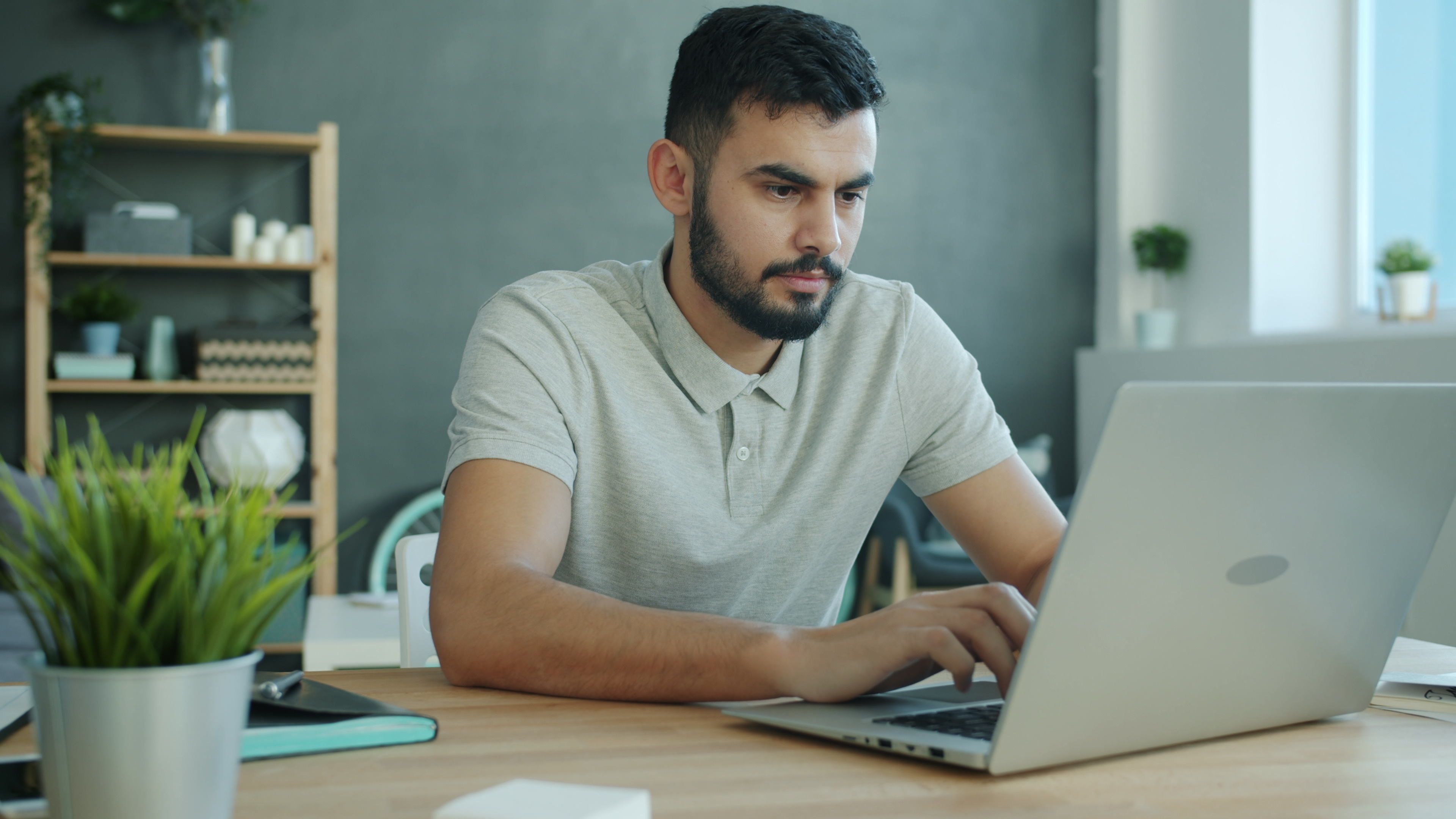 A man working at a laptop in a bright modern home office