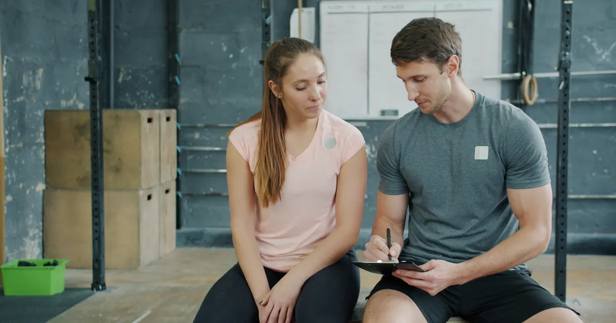 A trainer and client reviewing a written training plan together