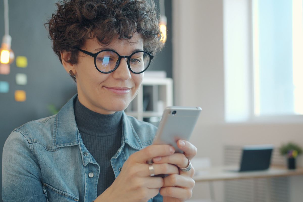 スマートフォンを手に微笑む若い女性