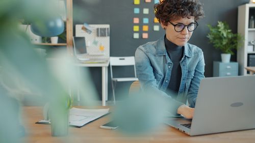 Free A woman working on a laptop in a modern home office with creativity in view. Stock Photo