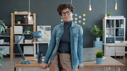 Free Confident person in a modern office with plants and stationery. Stock Photo