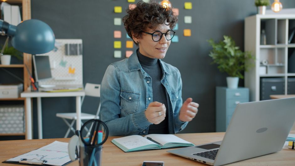 A woman engaging in remote work using a laptop in a stylish office.