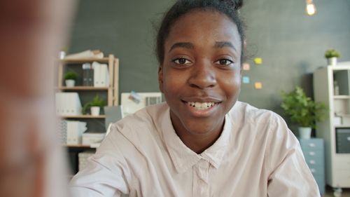 Free A smiling African-American teenager in a modern office space. Stock Photo