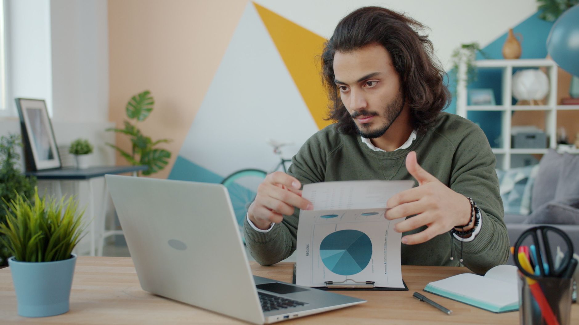 Líder estudando um relatório analítico impresso ao lado de um computador portátil.