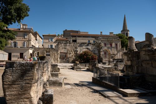 Free Explore the Roman ruins in Arles, France, with stunning historic architecture under clear blue skies. Stock Photo