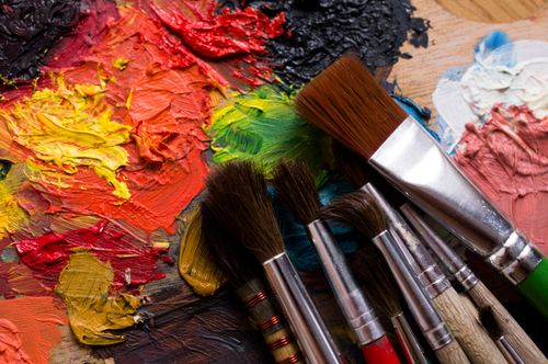 Free Colorful palette with vibrant paints and brushes ready for a creative painting session. Stock Photo